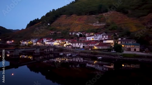 Belesar village with autumn vineyards reflecting in the tranquil miño river