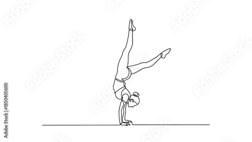 Woman performs elegant handstand with one leg raised high