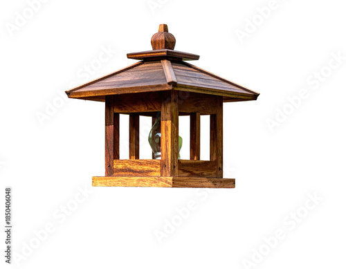 Wooden structure with a roof, cut out from a background, appears to be a bird feeder