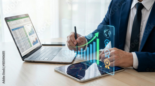 Businessman analyzing data on laptop with digital growth charts, representing business success and innovation
