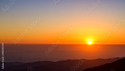 Wallpaper Mural A vibrant sunrise over silhouetted mountain ridges, with a gradient sky of blues and oranges Torontodigital.ca
