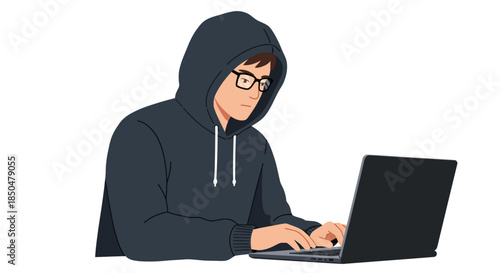 Young man wearing a hooded sweatshirt and glasses intently typing on a laptop computer symbolizing coding technology and cybercrime cybersecurity