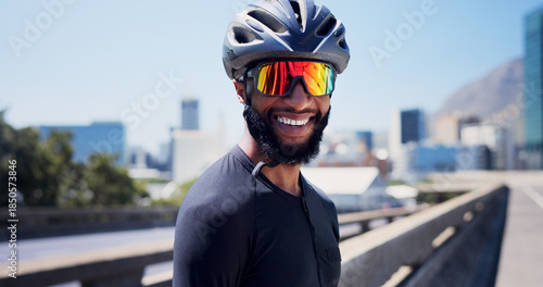 Foto Black man, cyclist and smile with sunglasses in city, fitness and helmet on bridge, break or pride in street