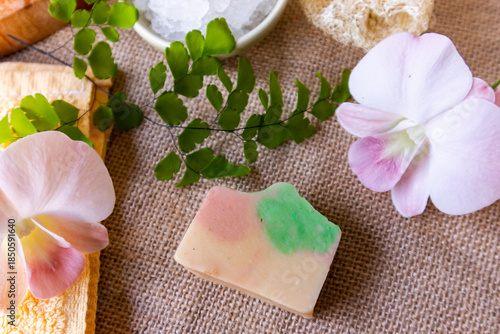 Handmade soap on burlap with orchid flower, towel and bath salt, Concept of sustainable use, bath products. Flat lay