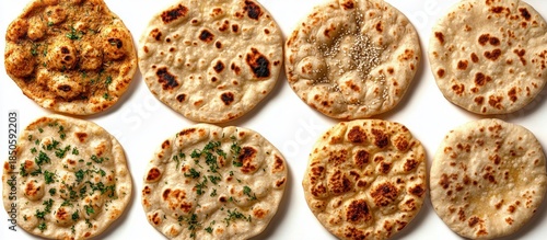 assorted freshly cooked round flatbreads with golden charred spots, sesame seeds and herb garnish on a white surface, warm and inviting comfort food