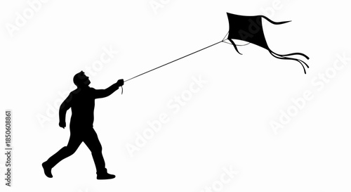 Black silhouette of a person running while flying a kite.