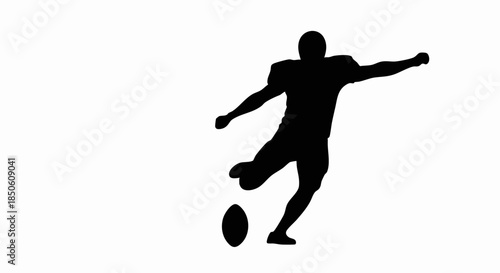 Silhouette of an American football player kicking the ball.