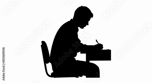 Silhouette of a person writing at a desk studying or working.