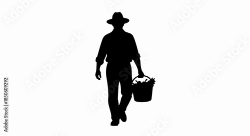 Silhouette of a farmer walking with a bucket in his hand.
