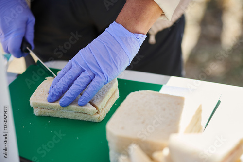 Принти на полотні Food Safety Worker Preparing Sandwich On Green Cutting Board For Service