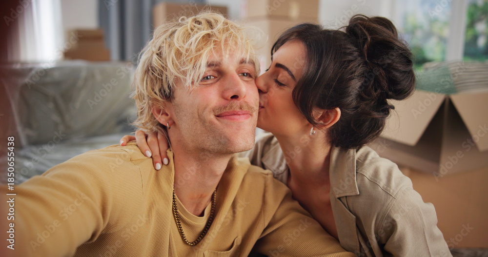 Fototapeta premium Smile, couple and selfie with kiss at new house for photography, social media post and moving in. People, love and profile picture update for real estate, property investment and relocation memory