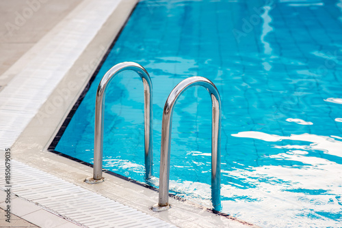 Ladder stainless handrails for descent into swimming pool.