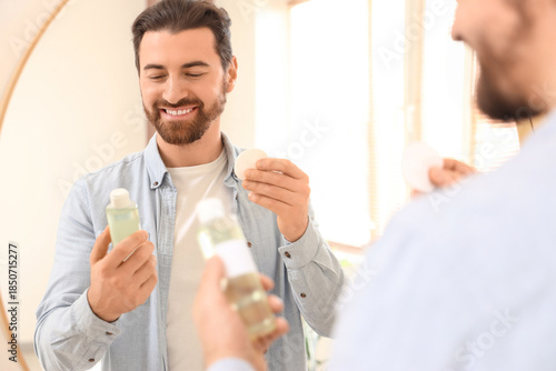 Handsome man with bottle of...