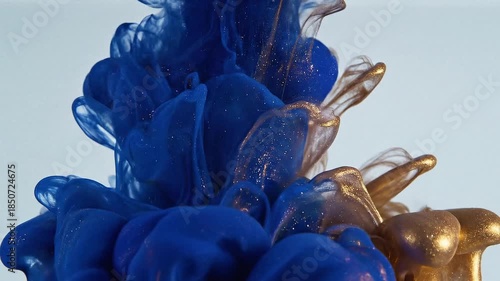 Abstract Blue and Gold Ink Droplets Swirling in Water, Dynamic Fluid Motion