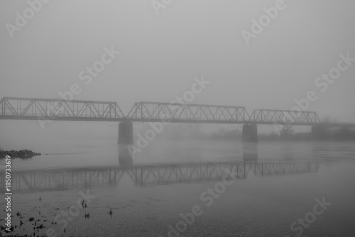 Brücke über einem Fluss an einem nebligen Abend in Deutschland