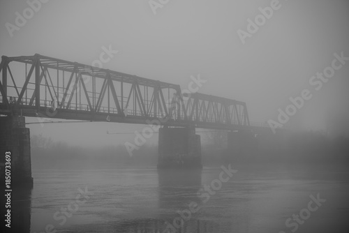 Brücke in der Nebelstimmung über einem Fluss bei grauem Wetter
