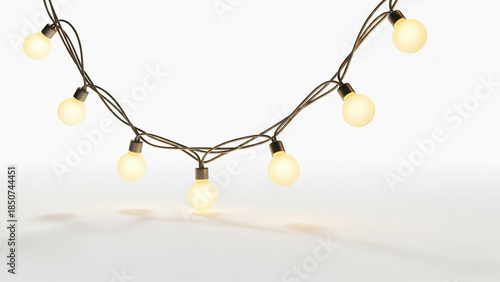 A string of warm glowing light bulbs suspended against a white background, casting soft shadows on a surface.