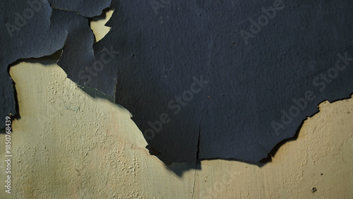 Wall with peeling and damaged black paint surface