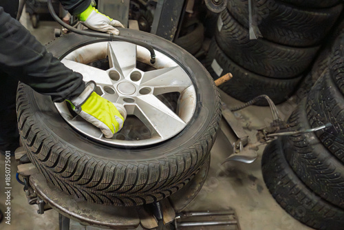 Fotografía Professional tyre technician in high-visibility gloves operating tyre changer eq