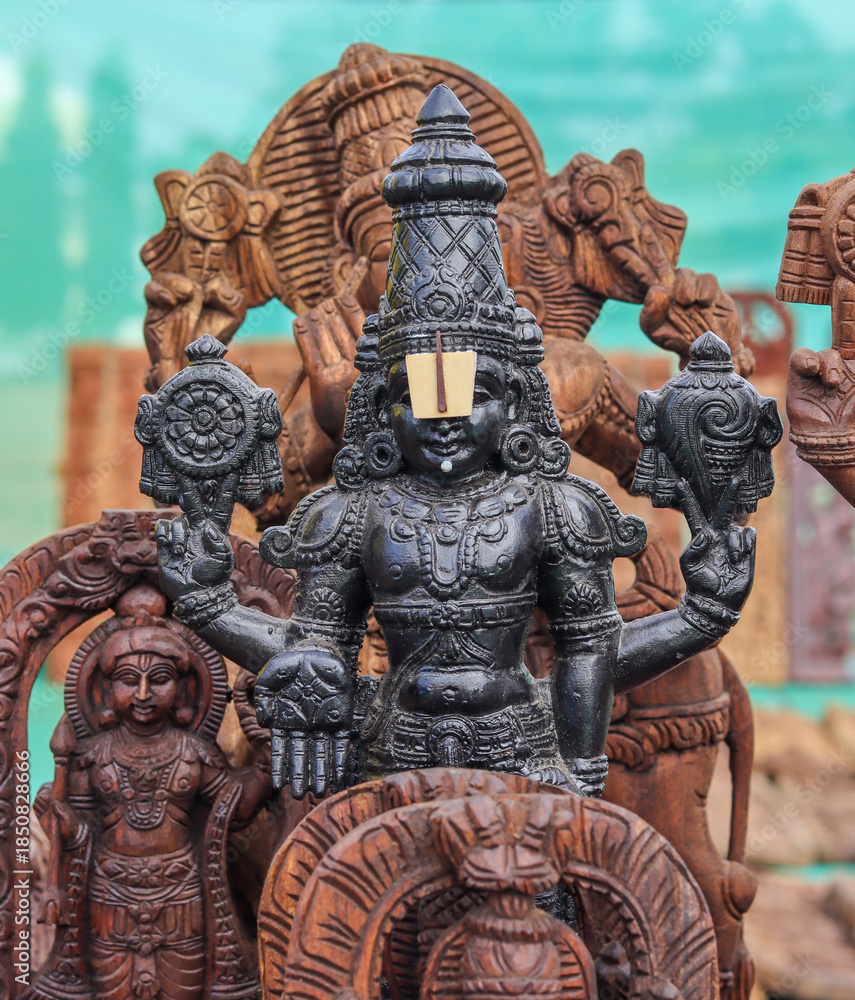 Obraz premium A Divine sculpture of Lord Balaji carved from sacred wood, idol, statue, Srinivasa, Hinduism, intricate, spirituality, Venkateshwara, worship, god, India.