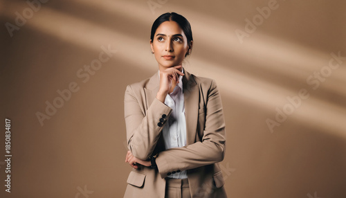 Confident Professional Businesswoman Thinking Strategically Against Minimal Neutral Background.