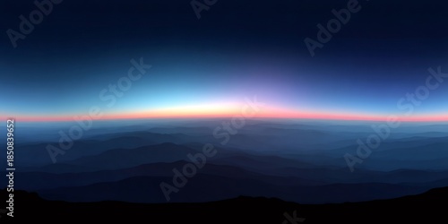 Mountain range silhouettes during dawn, showing glowing horizon and changing sky colors at sunrise