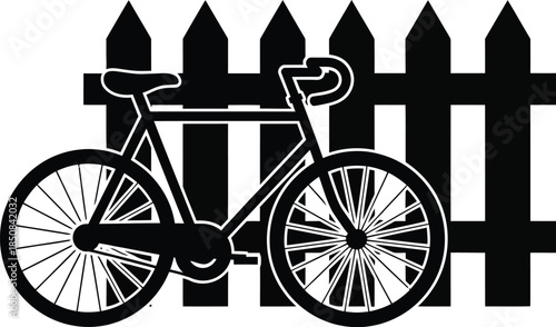 Silhouette of a bicycle parked beside a fence