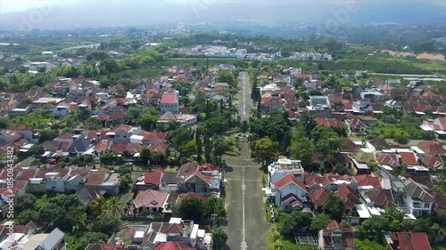 High-angle aerial view of a circular green park surrounded by houses in a suburban neighborhood.