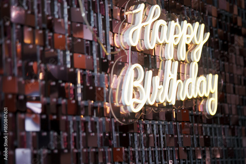 A birthday sign with LED lights illuminating a glossy background.