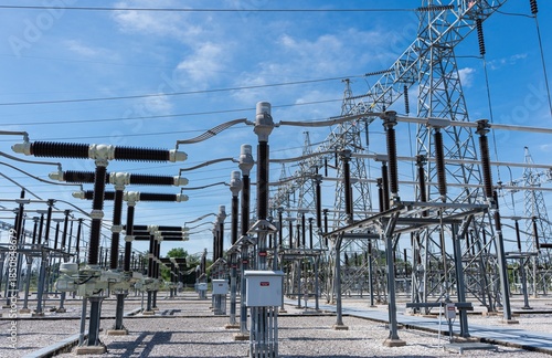 Perspective view of high voltage electrical equipment and transmission towers. Industrial energy plant providing power to the city grid with engineering excellence and safety.