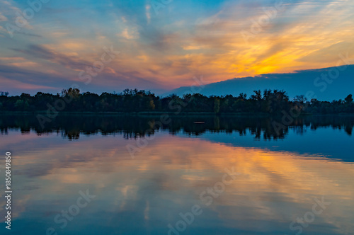 Wallpaper Mural Sunset over a calm lake, reflection and trees in the background in the early evening. Torontodigital.ca