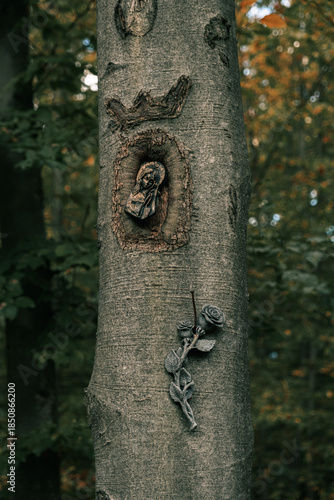 A religious sculpture nailed to a tree.