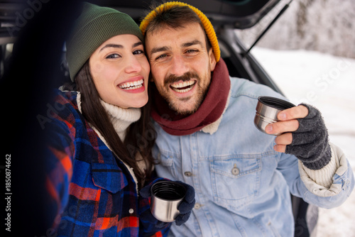 Couple having fun taking selfies while taking a winter vacation road trip break
