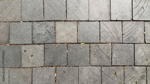 Texture of Andesite natural stone floor tiles in grey with natural diagonal line patterns neatly arranged in an outdoor area. © Muhammad