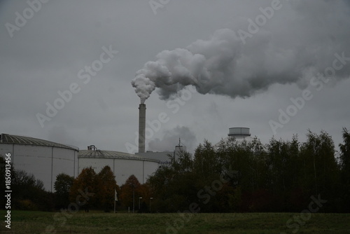 Smoke clouds from a sugar factory operating at full capacity in October. In the foreground, a long pile of sugar beet tubers (Beta vulgaris). Nordstemmen, Lower Saxony, Germany.