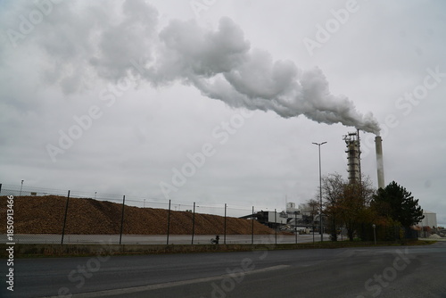 Smoke clouds from a sugar factory operating at full capacity in October. In the foreground, a long pile of sugar beet tubers (Beta vulgaris). Nordstemmen, Lower Saxony, Germany.