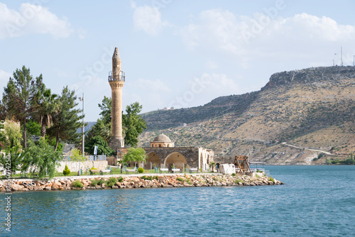 Old halfeti grand mosque minaret standing partially submerged by the blue waters of the euphrates river, showcasing ancient architecture and cultural heritage in turkey