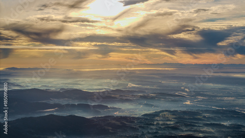 Sonnenaufgang über den Bergen mit Wolken und Nebel in der Ferne