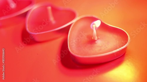 Red burning candles in the shape of a heart with a blazing flame. Tongues of fire on a red background. Valentine's day, passion, love, feelings, romantic mood concept.