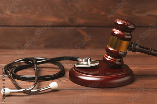 A stethoscope and hammer on a desk. Medical malpractice, personal injury lawyer, and healthcare legal aspects concept.Lawyer.Legal definition of medical negligence. Law concept.Healthcare and Medicine