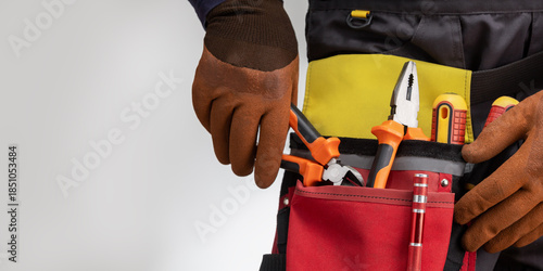 Close-up of tools belt on electrician worker. Banner with copy space.