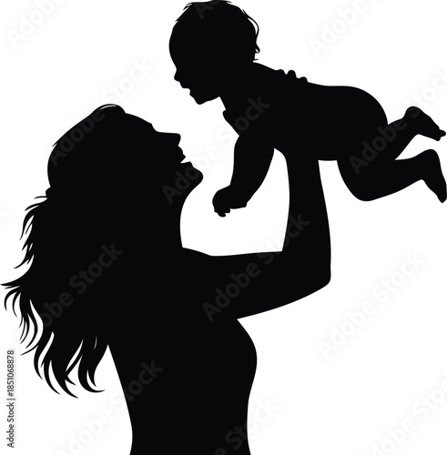 A loving mother holds her happy baby up in the air in a touching silhouette portrait