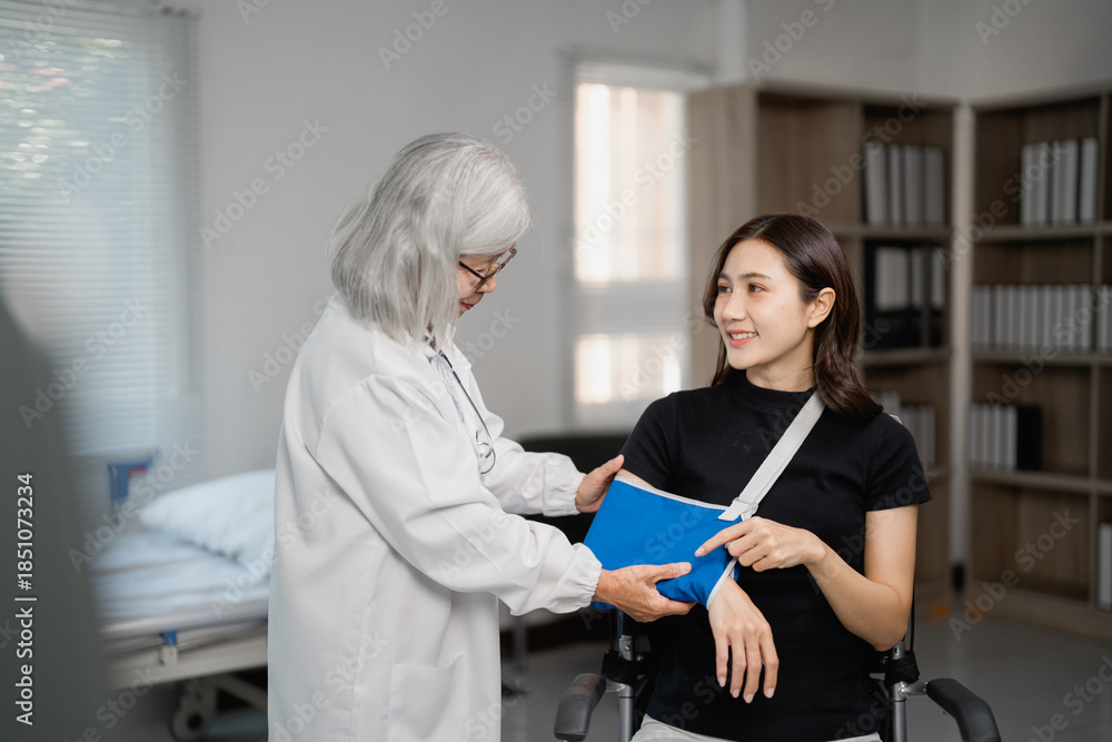 Obraz premium Doctor examining patient with arm injury and sling