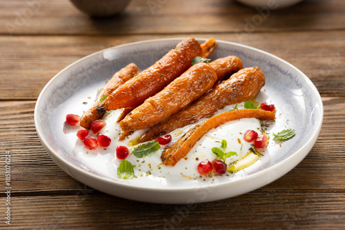 Whole roasted carrots on cheese on plate winter food