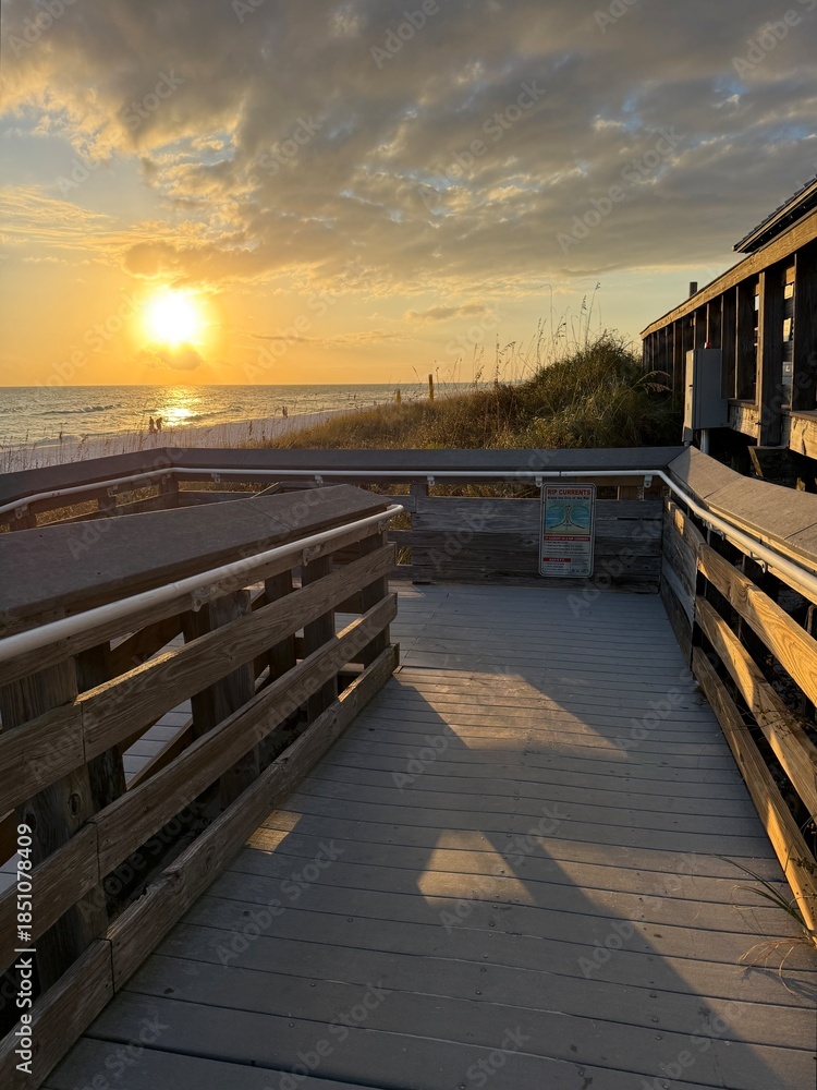 Obraz premium Miramar Beach, Florida public beach access with golden sun setting over the Gulf of Mexico 