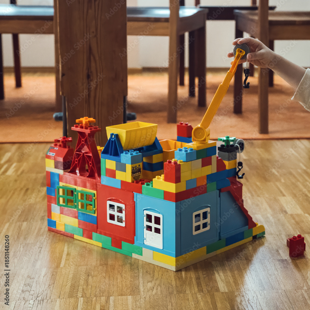 Fototapeta premium colorful lego house with crane, playful construction and creativity in action