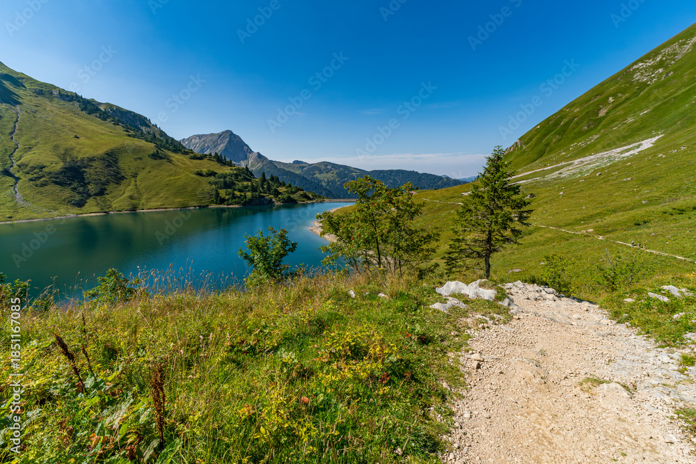 Fototapeta premium Serene Mountain Lakeside Pathway Through Tannheimer Valleys Breathtaking Alpine Scenery