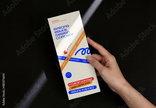 Template Mockup Vertical Flyer Branding and Identity Design Held in Hand with Dramatic Light on Dark Background