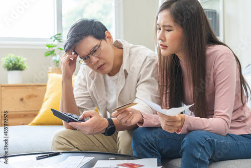 Stressed financial owe asian young couple love sitting suffer, stressed and confused by calculate expense from credit card bill, no money to pay, mortgage or loan. Debt, bankrupt or bankruptcy people.