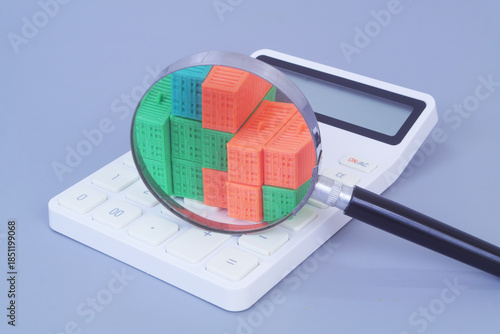 Many cargo containers on calculator under magnifying glass on grey background. Shipping and transportation cost concept.